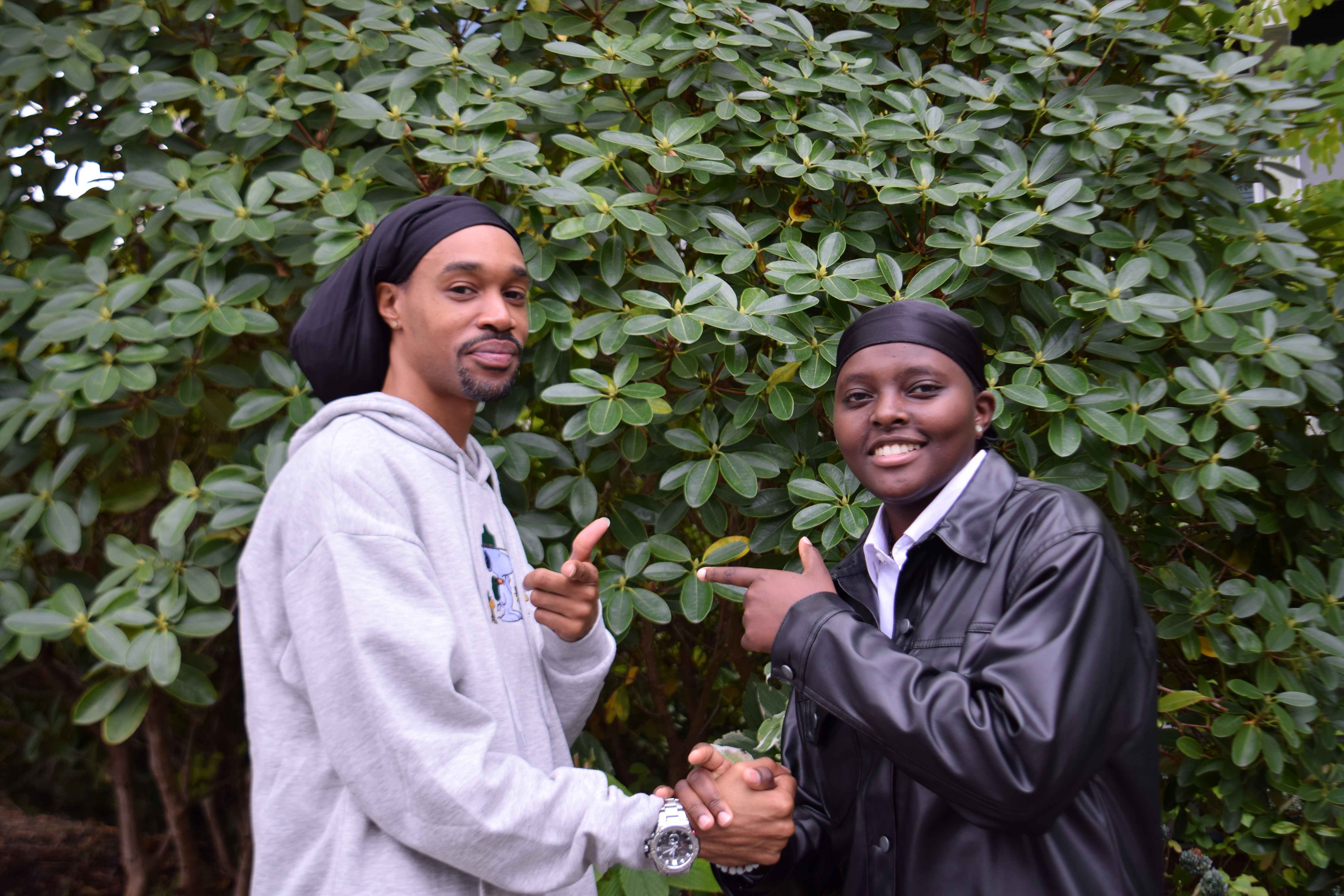 Grace & Demetrius pointing at each other while smiling at the camera