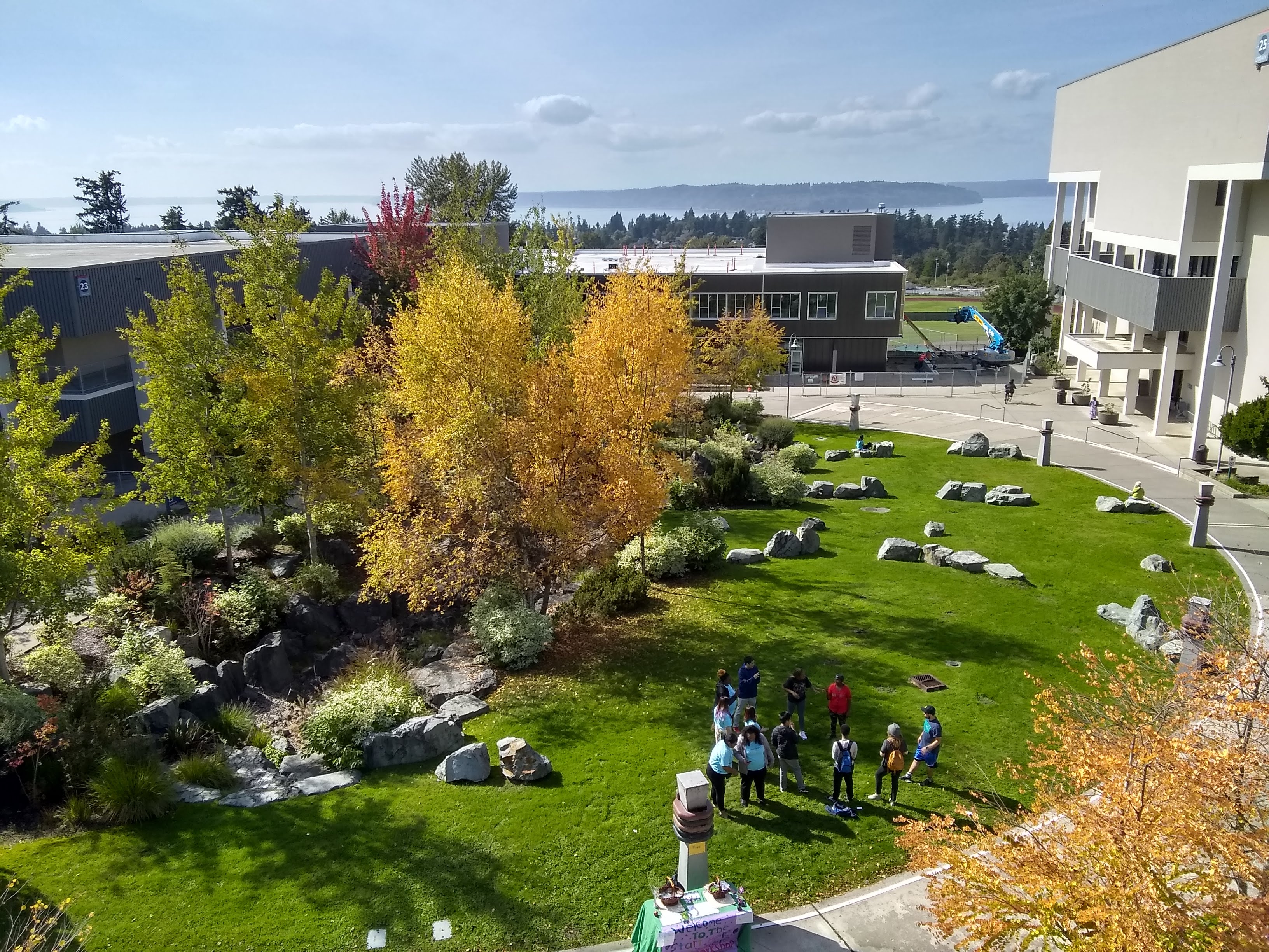 Overhead view of Highline campus with fall leaves and group of students in a circle on grass
